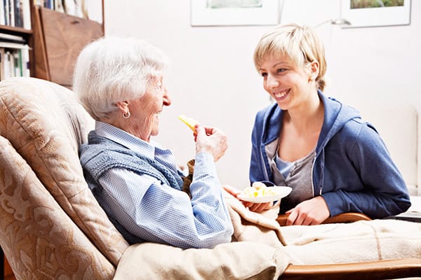 A Personal Support Worker helping a client with nutrition